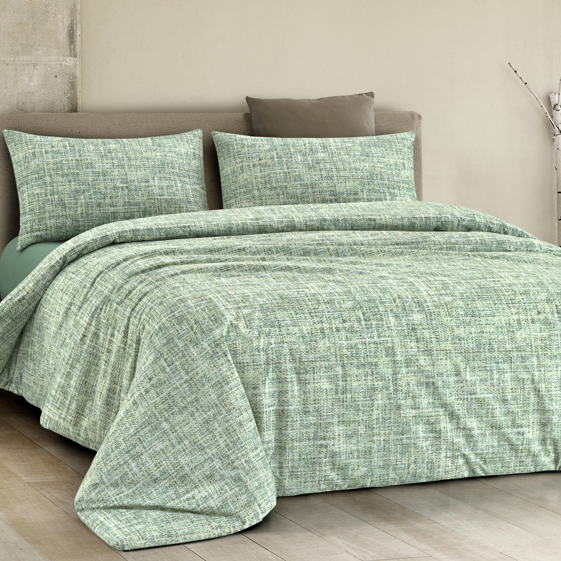 Copripiumino in cotone colore verde con disegno geometrico, posizionato su un letto elegante