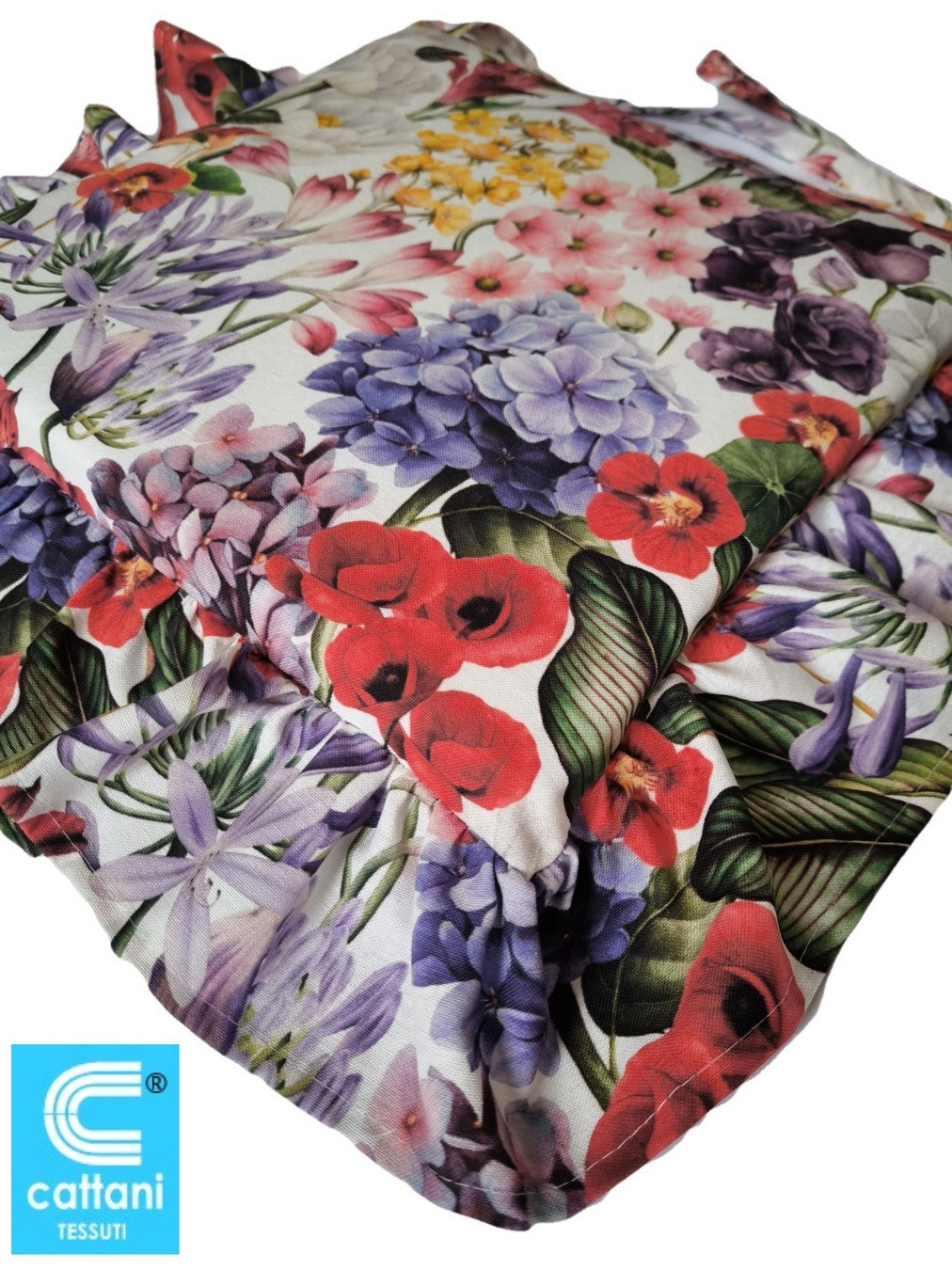 Dettaglio ravvicinato di un cuscino con volant a fantasia floreale multicolor, che mostra la texture del tessuto e i motivi decorativi.