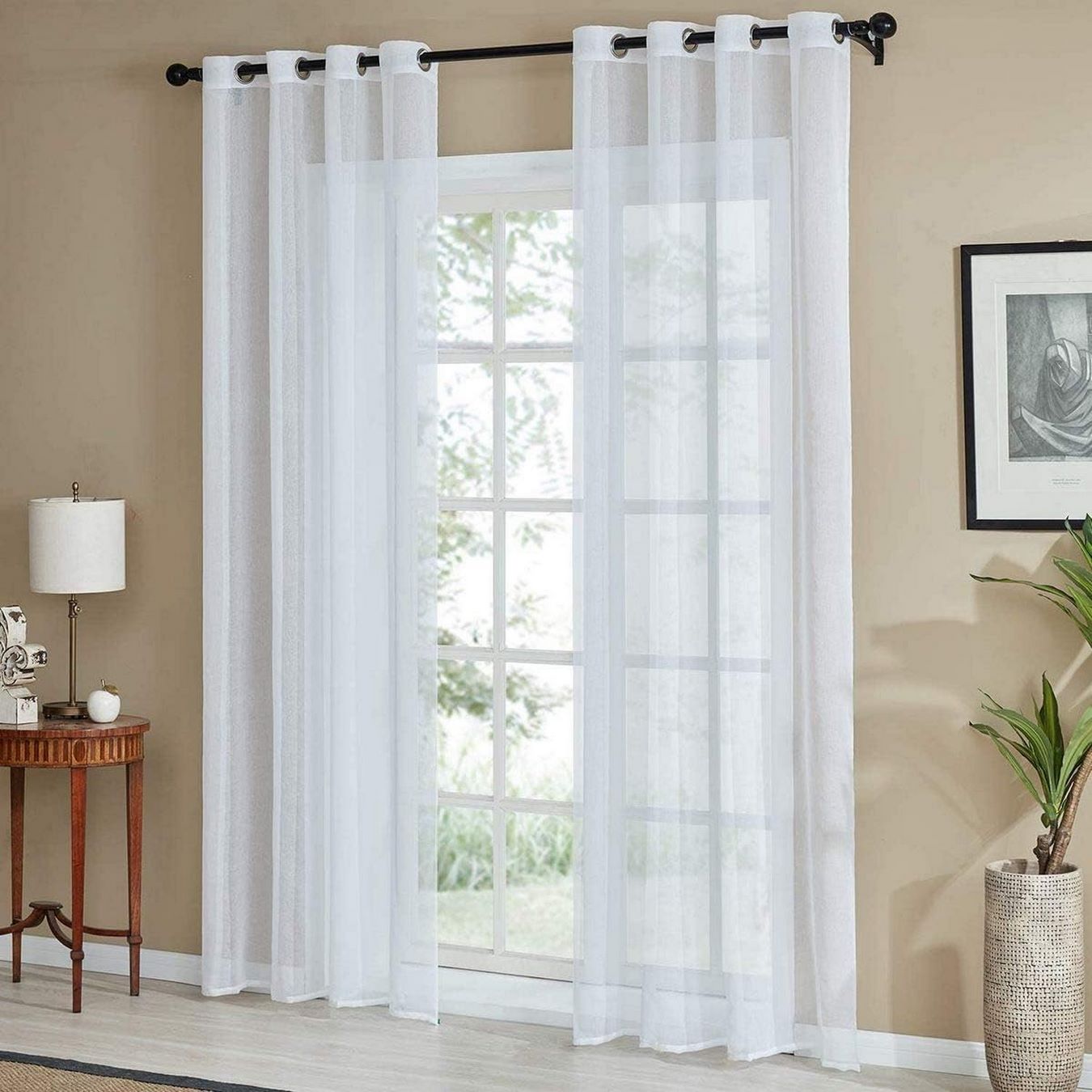 Tenda bianca effetto lino appesa a bastone in un salotto diverso, ambiente elegante e luminoso